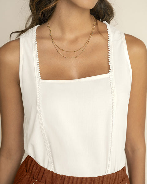 Blusa sin mangas de escote recto con detalle decorativo en frente#color_018-marfil